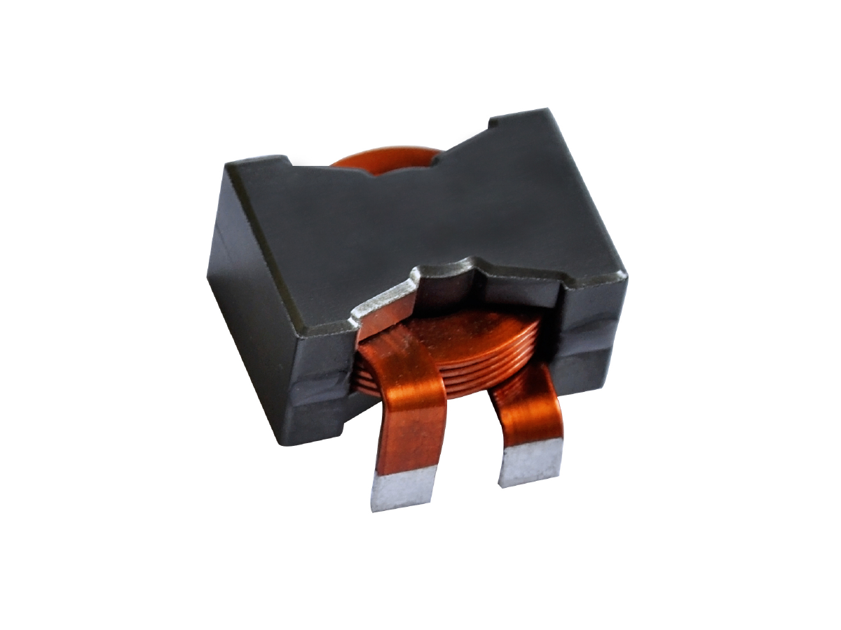 A close-up of an electronic component, likely a power inductor or high frequency transformer, with a black rectangular body and visible copper wire windings extending to two metal terminals. by Standex Edge