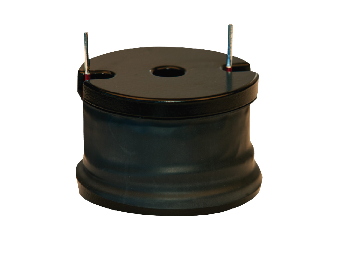 A black cylindrical power inductor with two metal prongs sticking out from the top, placed against a white background. by Standex Edge