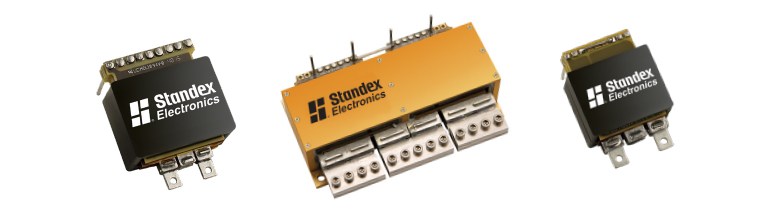 Three Standex Electronics electrical components of varying sizes, each with metallic terminals designed for optimal clearance and creepage distances, are arranged against a white background and labeled with the company logo. by Standex Edge